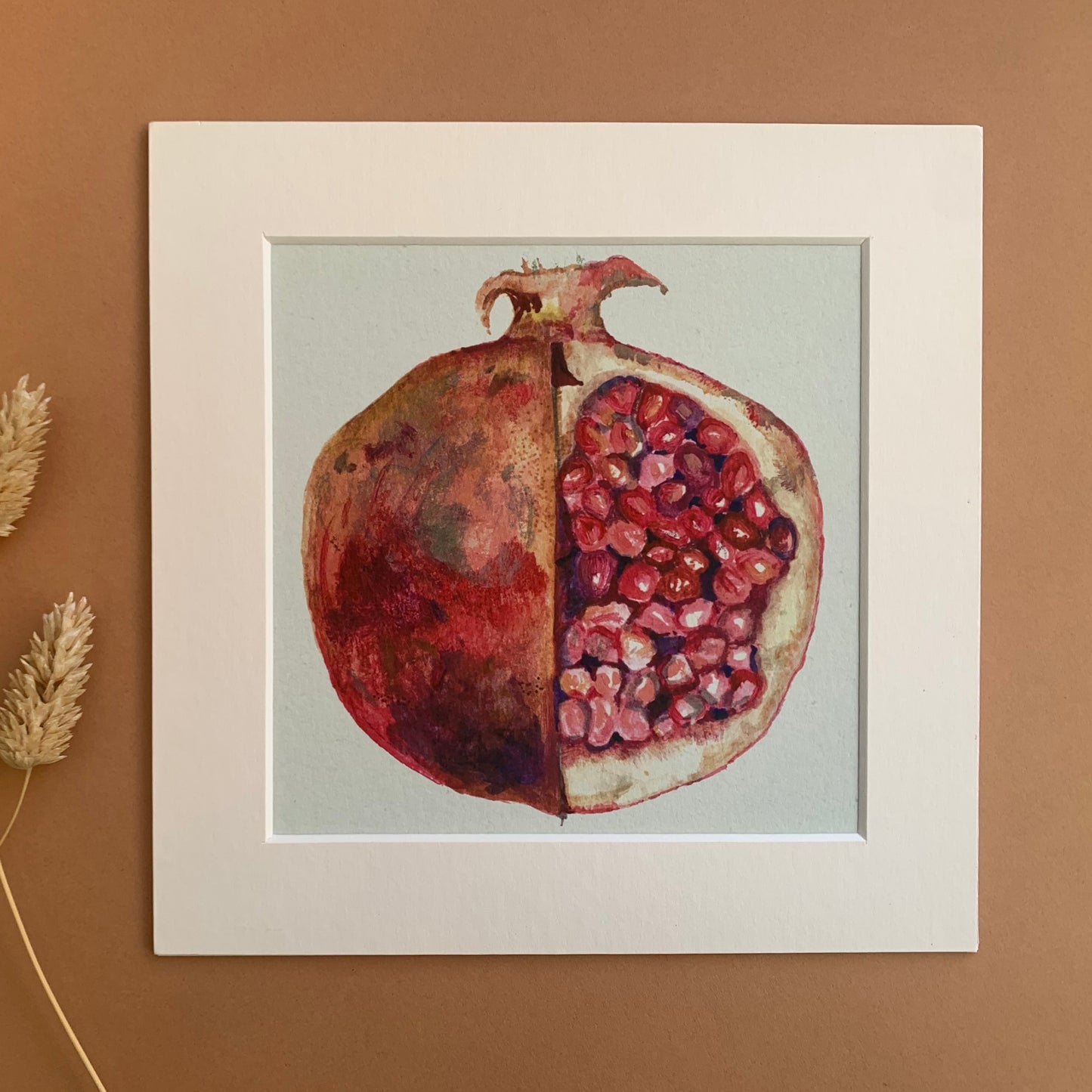 A mounted art print of a slices pomegranate