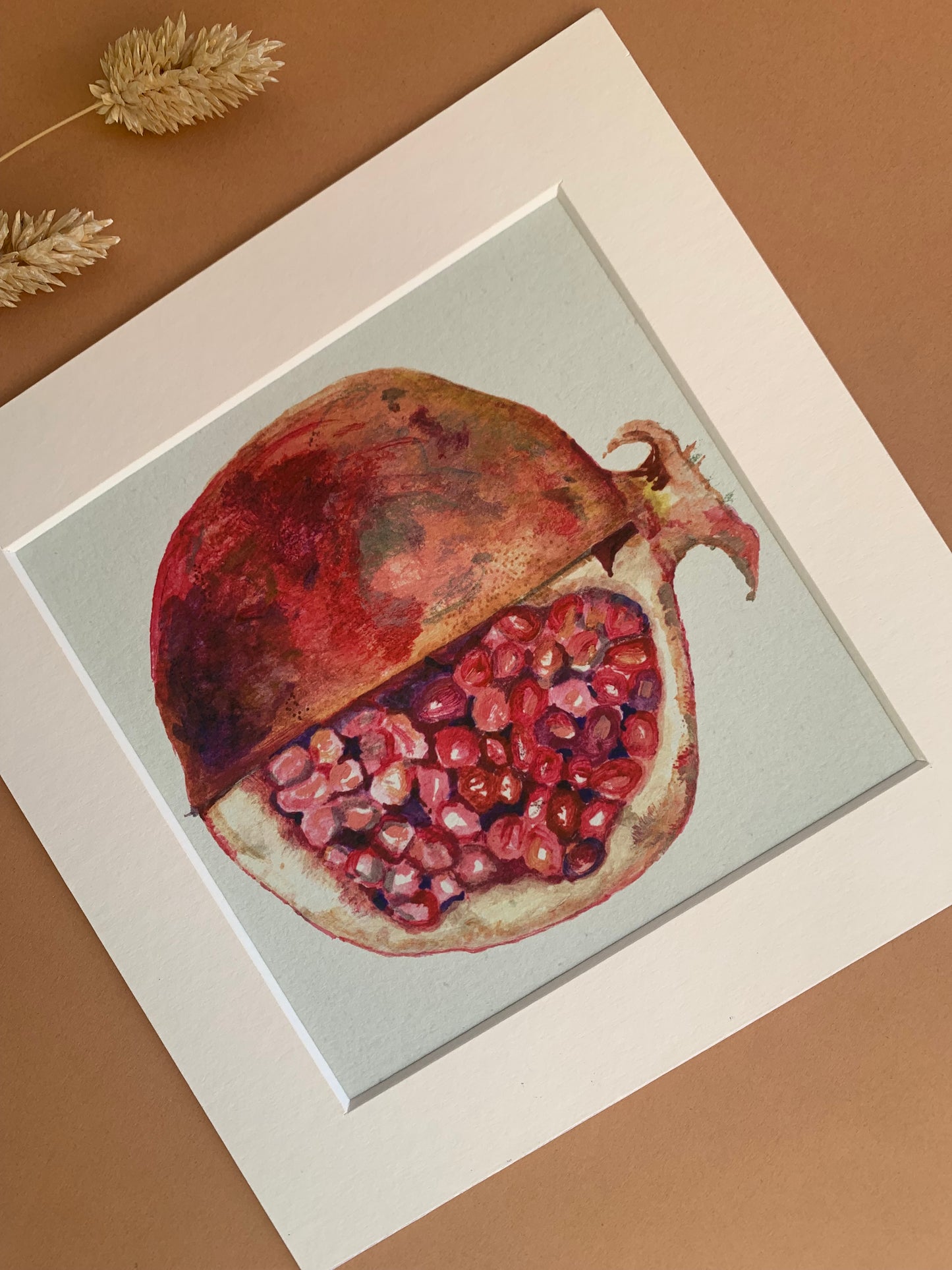 A fine art still life print of a pomegranate slices to reveal its seeds