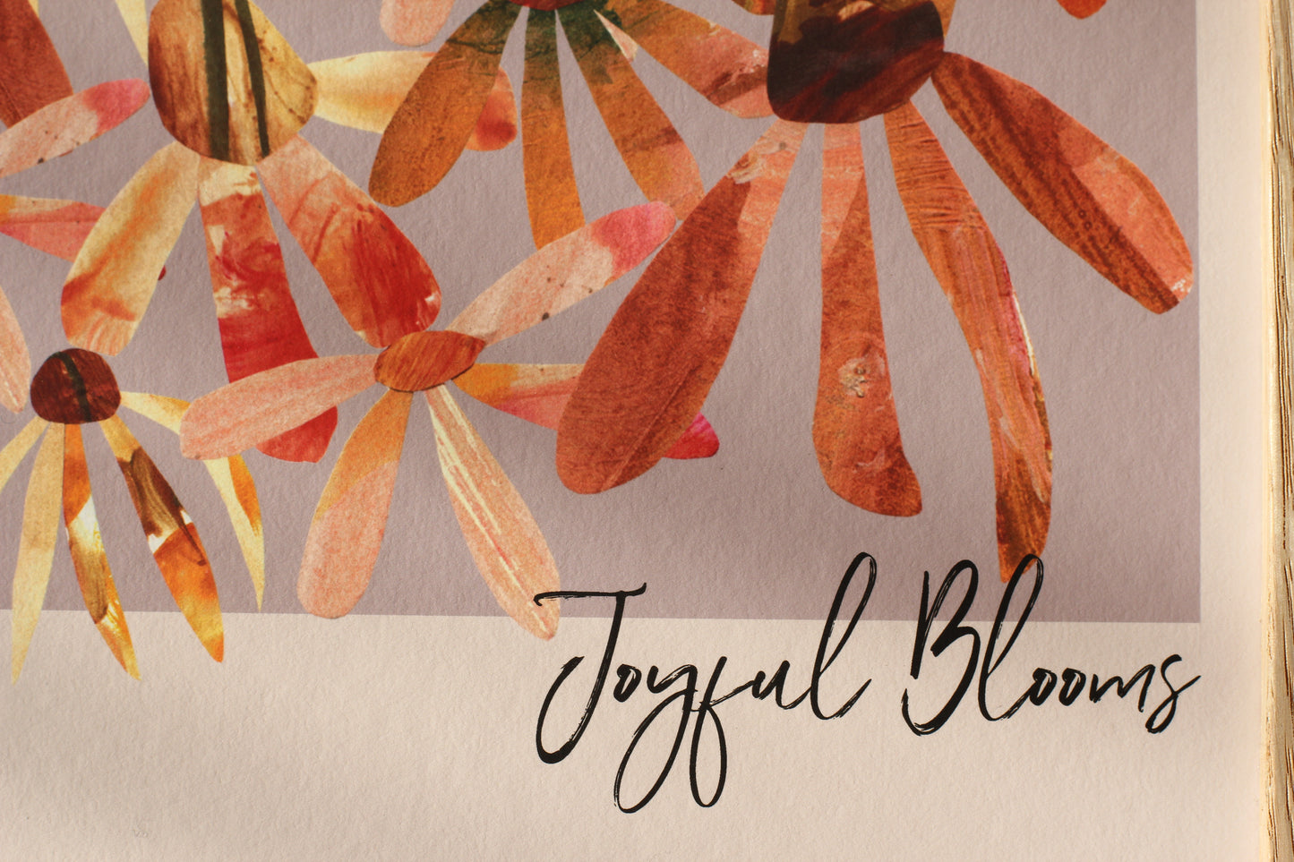 A detail of a floral art print. The close up shows echinacea and daisy flower heads in shades of orange against a lilac background. and the words 'joyful blooms' in handwritten black script.