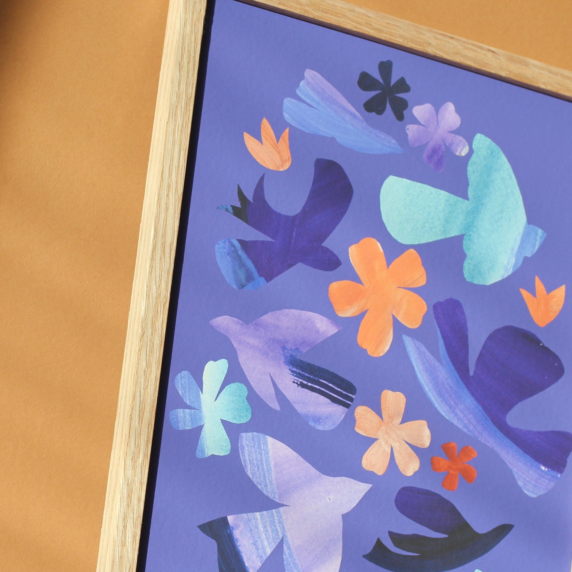 A close up of a bright, colourful art print of abstract flower forms and birds against a purple background. 